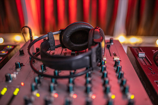 Close-up of boutique recording studio control desk, dj headphones for professional disc, equipment for sound recording studio, mixer and DJ headphones