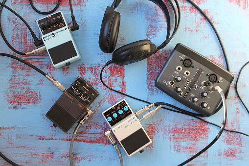 Guitar pedal, headset, and audio card on grunge background - music concept