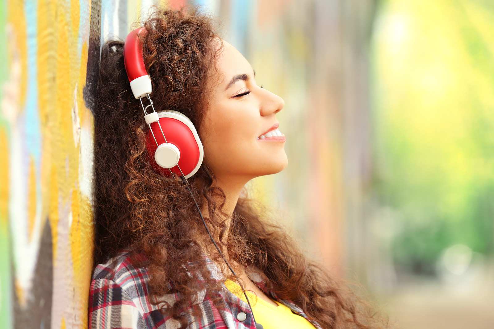 African American woman listening to music in headphones in the street
