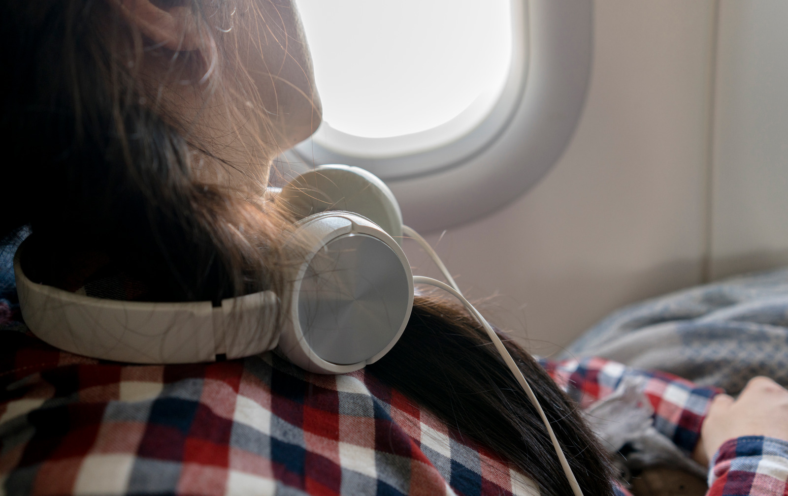 girl wearing headphone sleeping on airplane