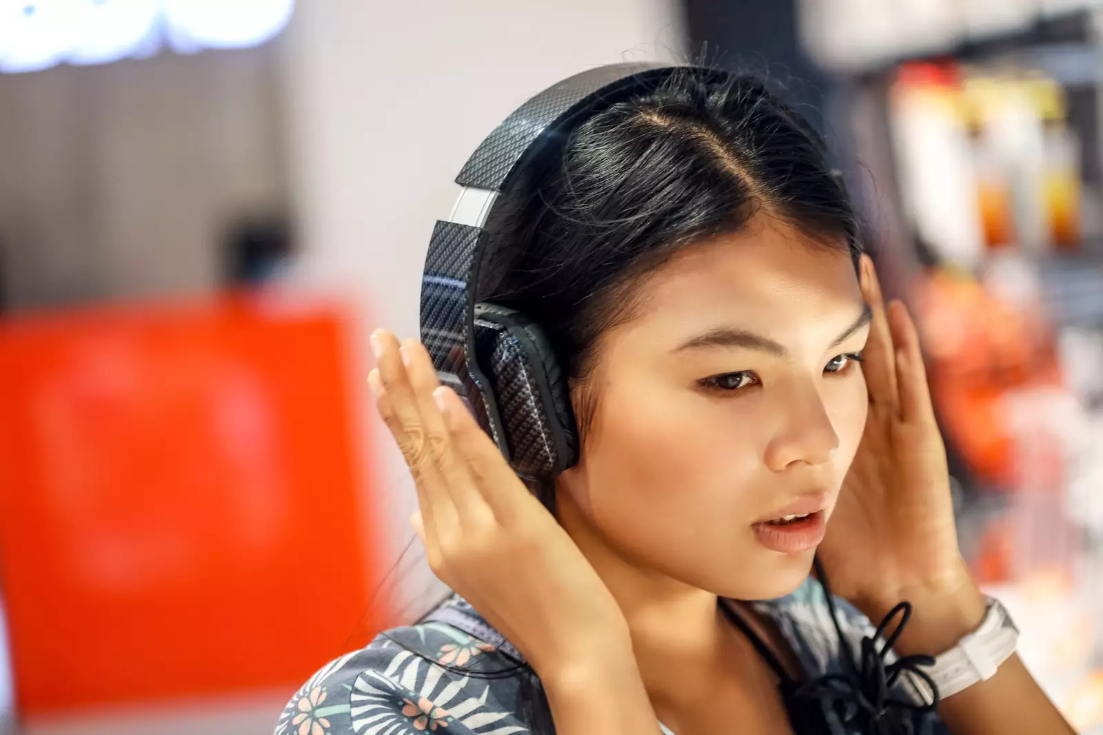 Woman trying on headphones in electronics store