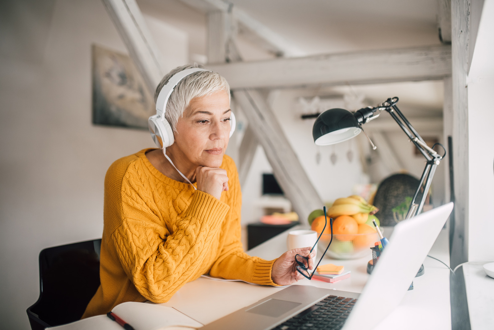 Business woman wearing headphones at home office